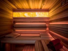 Podsvícený onyx Onice Honey dodává sauně luxusní atmosféru a jemné, relaxační světlo. Zakázkové kamenictví TONE OF STONE