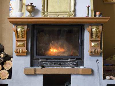 Krbová vložka s hořícím dřevem: i krb potřebuje před topnou sezonou vyčištěný a zkontrolovaný komín. (Zdroj: Shutterstock)